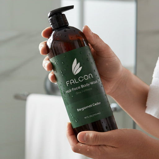 Person holding a bottle of Falcon body wash in a bathroom setting